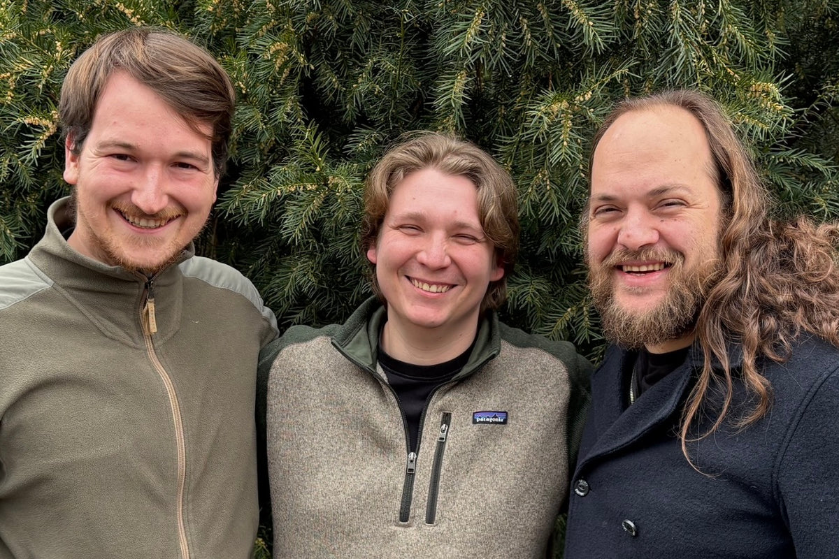 The Wyldforest team smiling in front of evergreen trees